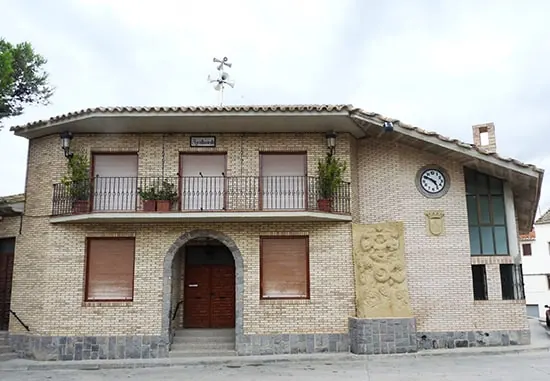 Fachada de ladrillo del Ayuntamiento de Maleján, con balcón y reloj